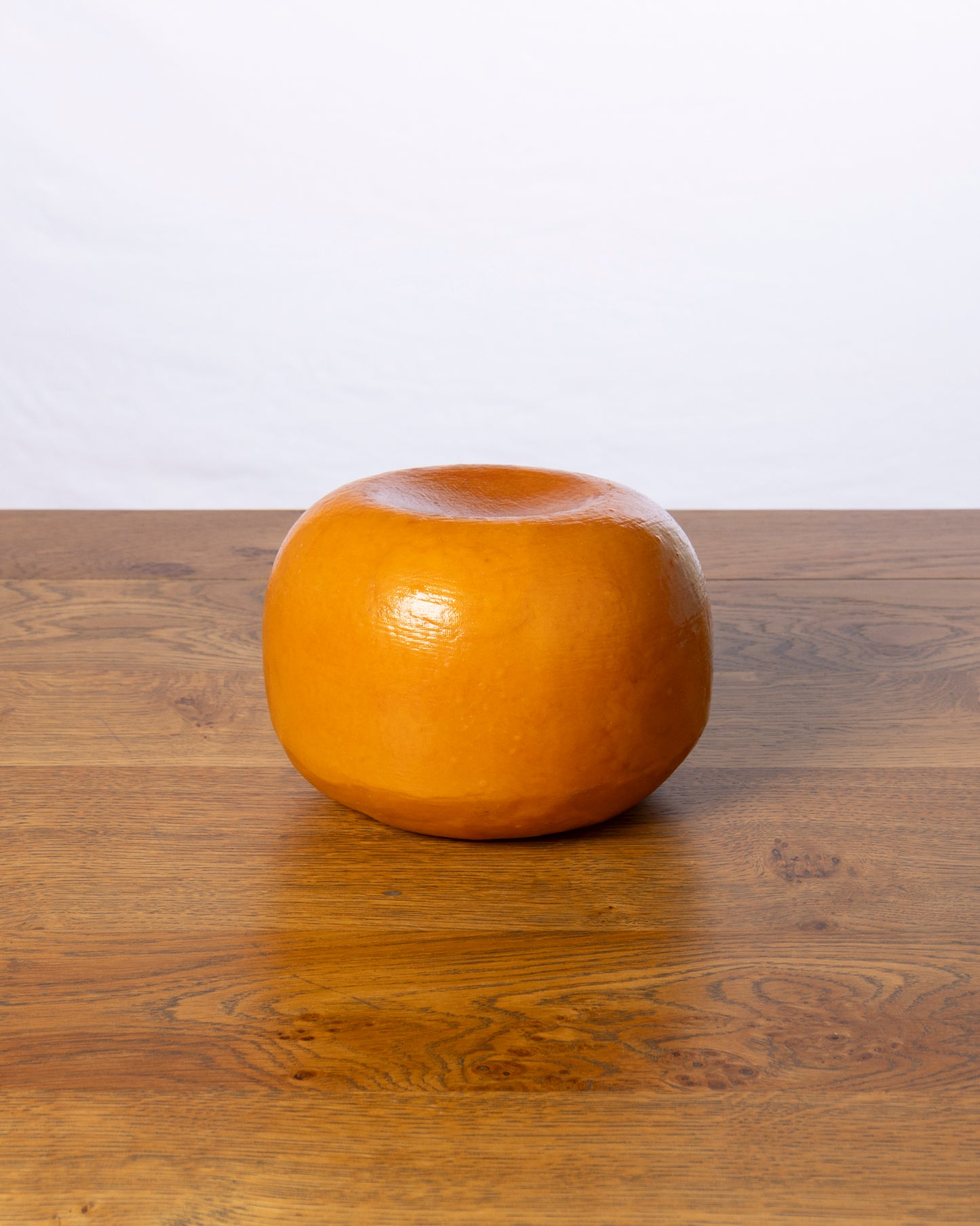 Een hele balvormige Commissie 40+ Overjarig kaas op een houten tafel.
