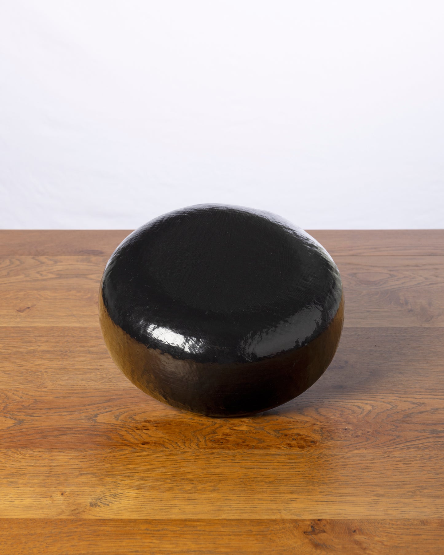 Een hele wielvormige Geitenkaas 50+ Oud op een houten tafel.
