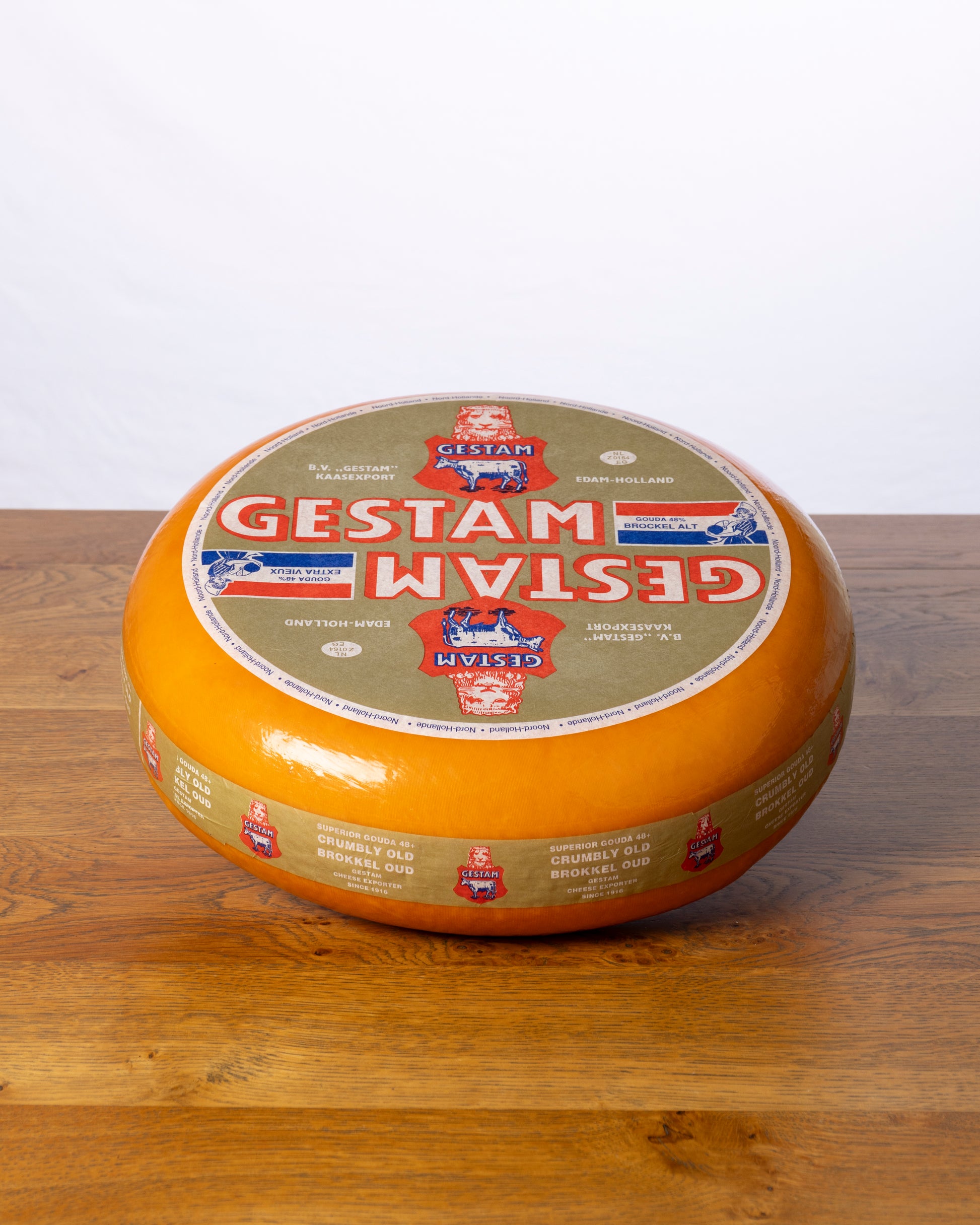 Een hele wielvormige Goudse 48+ Overjarig op een houten tafel.